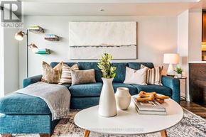 Toronto (Clanton Park) condo for rent - A living room with a blue couch, a white coffee table, and a painting on the wall.