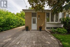 Richmond Hill (Crosby) apartment for rent - A small house with a white door and windows is surrounded by greenery.