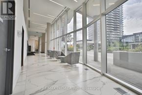 Vaughan (Concord) condo for rent - A hallway with a marble floor and glass walls leading to an outdoor area.