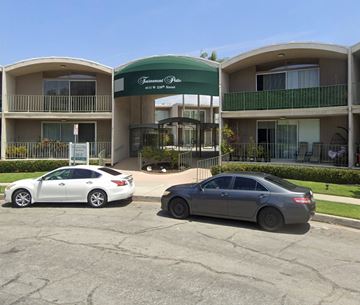 Torrance apartment for rent - Two cars are parked in front of a building with a green awning.