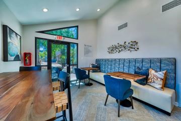 Scottsdale apartment for rent - A modern living room with a wooden table and blue chairs.