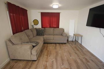 Colombia Falls apartment for rent - A living room with a grey couch and a white side table.