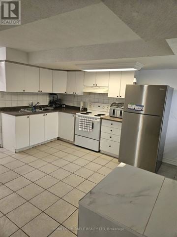 Brampton (Downtown Brampton) apartment for rent - A kitchen with white cabinets and a stainless steel refrigerator.
