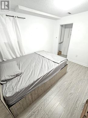 Brampton (Downtown Brampton) apartment for rent - A bedroom with a bed and a doorway leading to another room.