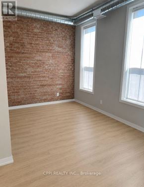 Peterborough (Town Ward 3) condo for rent - A room with a brick wall and wooden flooring.