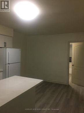 Toronto (Greenwood-Coxwell) apartment for rent - A white refrigerator in a room with a light on the ceiling.
