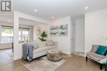 Oakville (Wo West) apartment for rent - A living room with a couch, a table, and a painting on the wall.