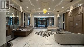 Mississauga (Fairview) condo for rent - A spacious lobby with a reception desk and a large chandelier.