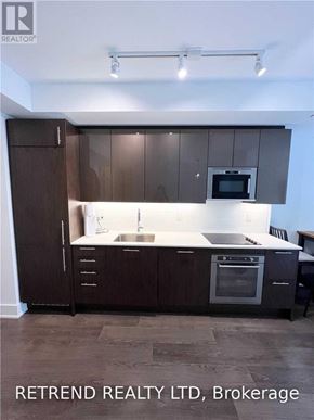 Toronto (Church-Yonge Corridor) condo for rent - A kitchen with dark brown cabinets and a white countertop.