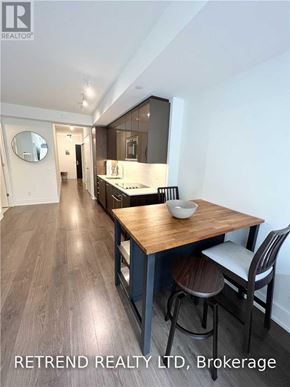 Toronto (Church-Yonge Corridor) condo for rent - A modern kitchen with a wooden table and chairs.