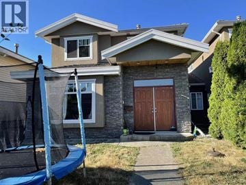Burnaby apartment for rent - A house with a brown door and a trampoline in the yard.