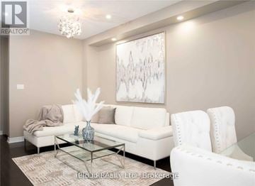 Brampton (Credit Valley) apartment for rent - A living room with a white couch, a glass coffee table, and a large abstract painting on the wall.
