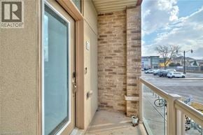 Beamsville townhouse for rent - A balcony of a building with a glass door and a brick wall.