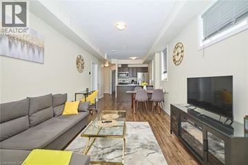 Beamsville townhouse for rent - A living room with a grey sofa and a glass coffee table.