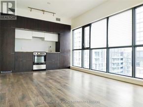 Toronto (Church-Yonge Corridor) condo for rent - A spacious kitchen with dark wood floors and a large window.
