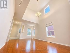 Richmond Hill (Oak Ridges Lake Wilcox) apartment for rent - A large, empty room with wooden floors and a chandelier hanging from the ceiling.