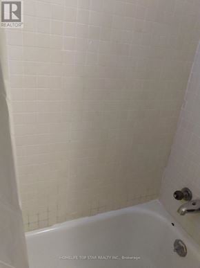 Toronto (Weston) apartment for rent - A white bathroom with a tub and shower.