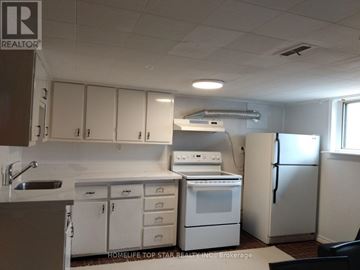 Toronto (Weston) apartment for rent - A white kitchen with a sink, stove, and refrigerator.