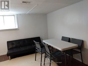 Toronto (Weston) apartment for rent - A black couch sits next to a white table in a room.