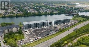 Welland (Broadway) condo for rent - A large building with a parking lot in front of it.