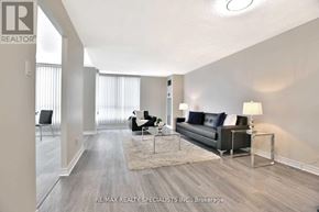 Toronto (Beechborough-Greenbrook) condo for rent - A spacious living room with a black sofa and a glass coffee table.