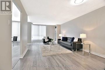 Toronto (Beechborough-Greenbrook) condo for rent - A spacious living room with a black sofa and a glass coffee table.