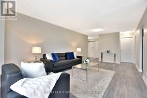 Toronto (Beechborough-Greenbrook) condo for rent - A living room with a black couch, a glass coffee table, and a white rug.
