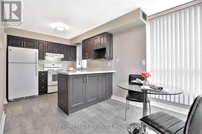 Toronto (Beechborough-Greenbrook) condo for rent - A modern kitchen with a glass table and black chairs.