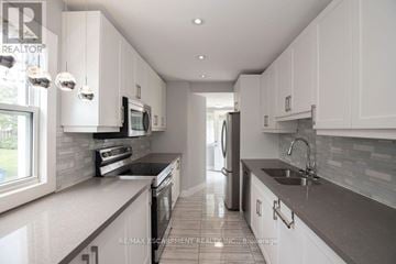 Hamilton (Homeside) apartment for rent - A modern kitchen with white cabinets and a tiled floor.
