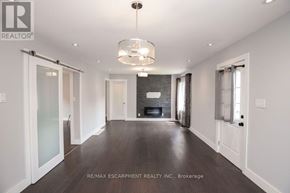 Hamilton (Homeside) apartment for rent - A spacious room with a fireplace and a chandelier.