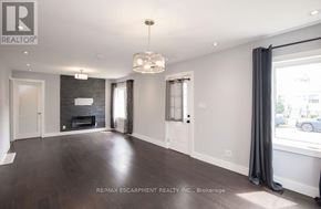 Hamilton (Homeside) apartment for rent - A spacious living room with a fireplace and hardwood floors.