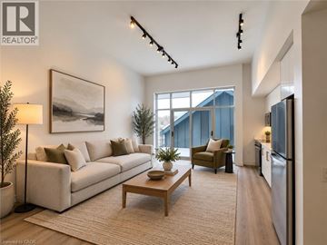 New Hamburg apartment for rent - A well-lit living room with a large window, a couch, a coffee table, and a painting on the wall.