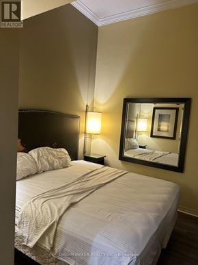 Toronto (Bay Street Corridor) condo for rent - A bedroom with a bed, lamp, and mirror.