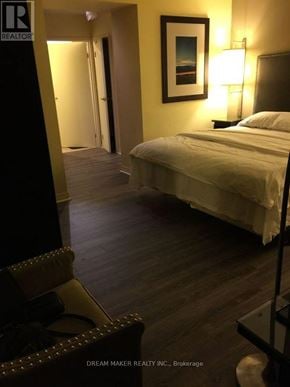 Toronto (Bay Street Corridor) condo for rent - A bedroom with a bed, a chair, and a painting on the wall.