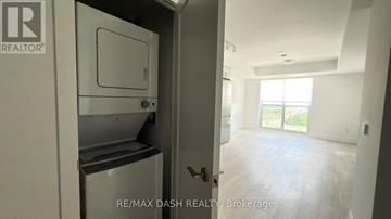 Oshawa (Windfields) condo for rent - A white refrigerator is in a kitchen with a door open.