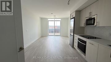 Oshawa (Windfields) condo for rent - A well-lit kitchen with white cabinets and a microwave above the stove.
