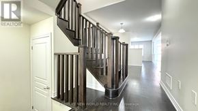 East Gwillimbury apartment for rent - A staircase with a wooden banister and a black tread is in a white room.