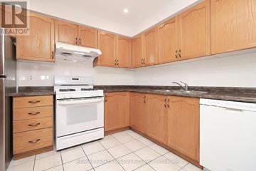 Brampton (Fletcher's Creek South) townhouse for rent - A kitchen with wooden cabinets and a white stove top oven.