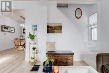 Hamilton (Eastmount) apartment for rent - A living room with a brown leather couch, a wooden floor, and a painting on the wall.