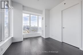 Toronto (Kensington-Chinatown) condo for rent - A spacious room with a view of the city through large windows.