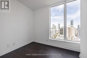 Toronto (Kensington-Chinatown) condo for rent - A room with a large window overlooking a cityscape.