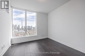 Toronto (Kensington-Chinatown) condo for rent - A room with a large window overlooking a city skyline.