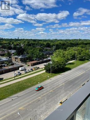 Toronto (Humber Heights) condo for rent - A car is driving on a road with a view of a residential area in the background.