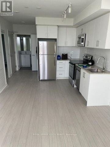 Toronto (Humber Heights) condo for rent - A kitchen with white cabinets and a stainless steel refrigerator.