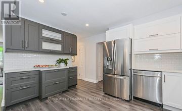 Kitchener apartment for rent - A modern kitchen with a stainless steel refrigerator and wooden cabinets.