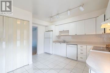 Toronto (Eringate-Centennial-West Deane) townhouse for rent - A kitchen with white cabinets and appliances.