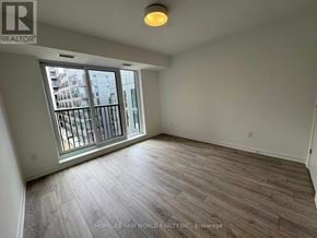 Toronto (Regent Park) condo for rent - A room with a large window and wooden flooring.