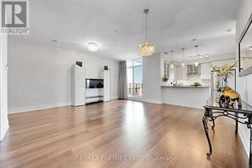 Vaughan (Concord) condo for rent - A spacious living room with wood flooring and a dining area with a table set for two.