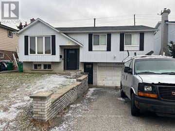 Mississauga (Malton) apartment for rent - A white house with a black door and windows is shown with a van parked in front.