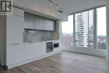 Toronto (Church-Yonge Corridor) condo for rent - A modern kitchen with white cabinets and a large window overlooking the city.